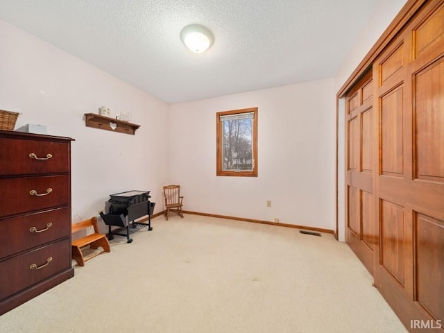 carpeted office space featuring a textured ceiling