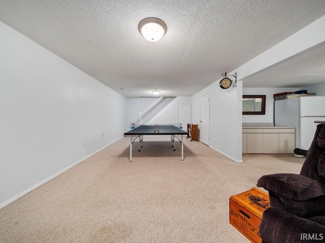 game room with light colored carpet and a textured ceiling