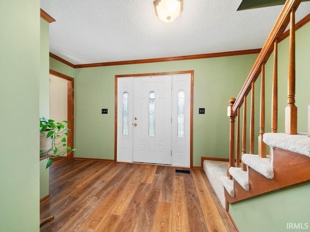 foyer featuring crown molding, dark wood-type flooring, and a textured ceiling