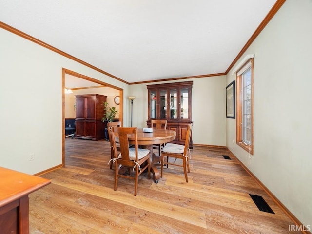 dining space with crown molding and hardwood / wood-style floors