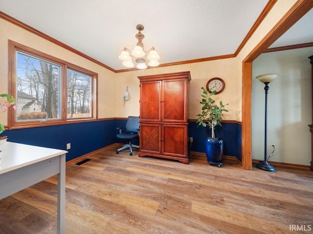 office space featuring an inviting chandelier, light hardwood / wood-style flooring, and ornamental molding