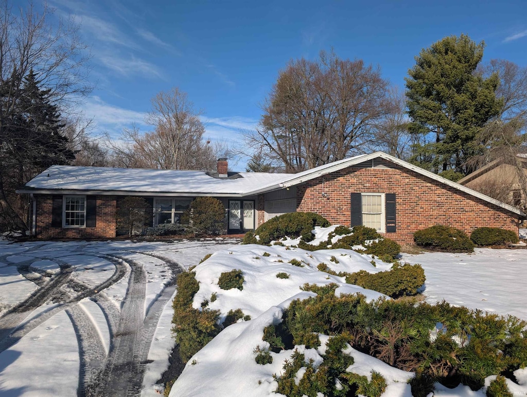 snow covered property featuring a garage