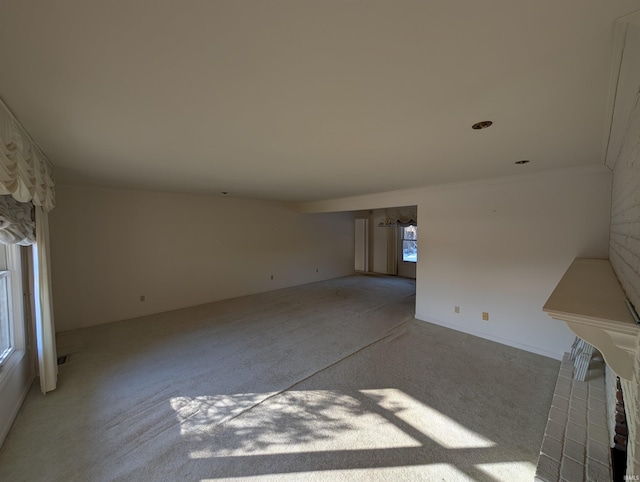 unfurnished living room featuring light colored carpet and ornamental molding