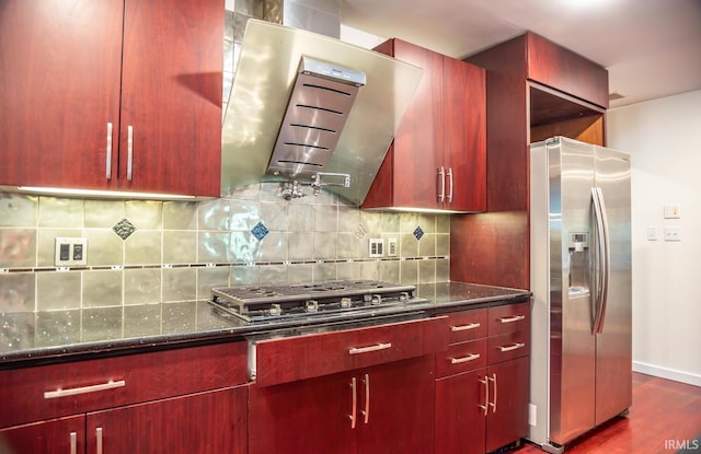 kitchen with dark stone countertops, backsplash, stainless steel appliances, dark hardwood / wood-style floors, and exhaust hood