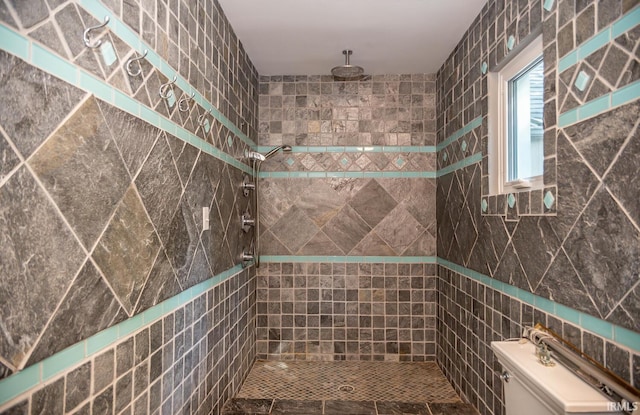 bathroom with tiled shower, tile walls, and toilet