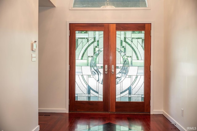 entryway featuring dark wood-type flooring, a wealth of natural light, and french doors