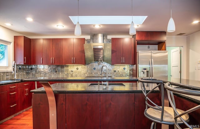 kitchen featuring sink, decorative light fixtures, stainless steel fridge with ice dispenser, and decorative backsplash