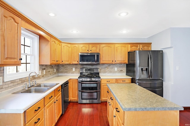 kitchen with dark hardwood / wood-style flooring, sink, decorative backsplash, and appliances with stainless steel finishes