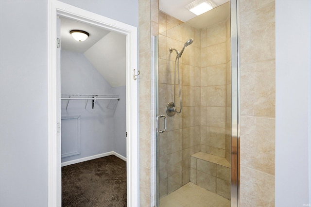 bathroom with lofted ceiling and a shower with door