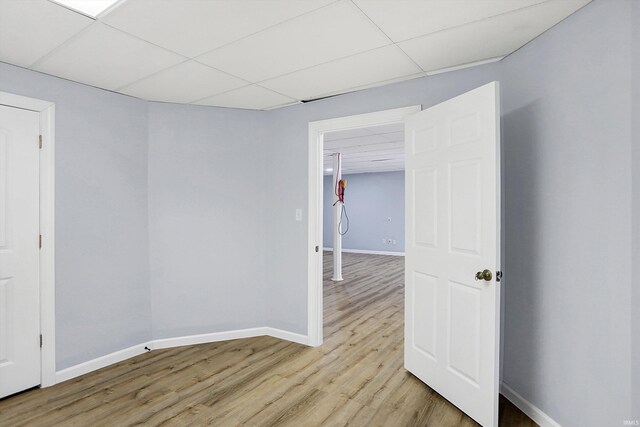 spare room featuring light hardwood / wood-style floors and a drop ceiling