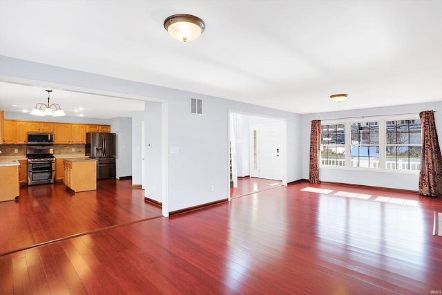 unfurnished living room with an inviting chandelier and wood-type flooring