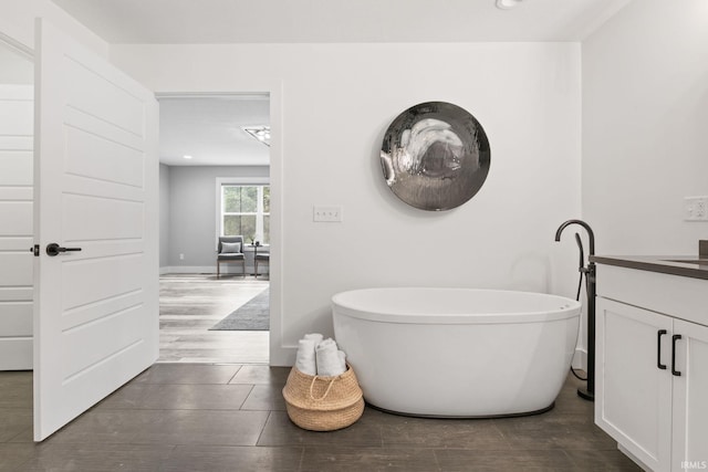 bathroom featuring vanity, a tub, and hardwood / wood-style floors