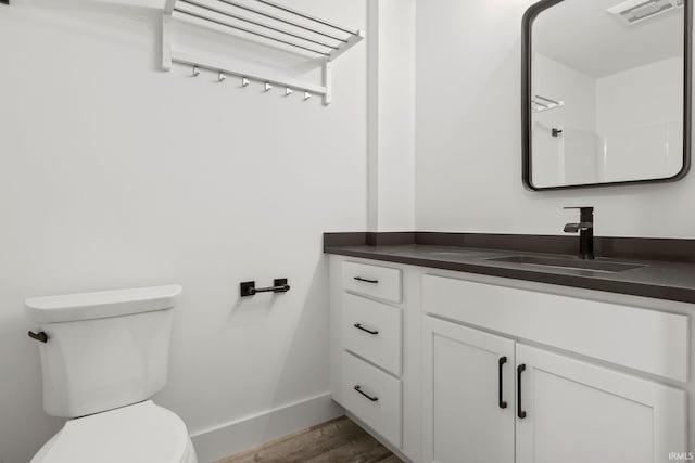 bathroom featuring vanity, hardwood / wood-style flooring, toilet, and walk in shower