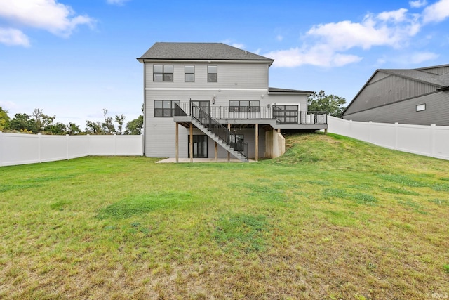 rear view of property with a wooden deck, a lawn, and a patio