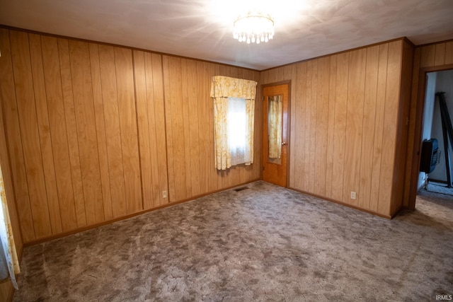 unfurnished bedroom with ornamental molding, light colored carpet, and wood walls