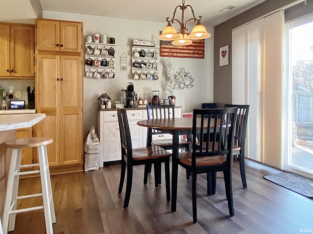 dining space with dark wood-type flooring and a notable chandelier