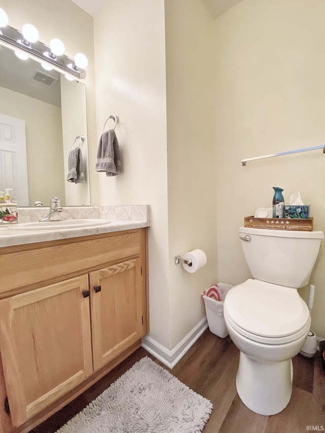 bathroom with vanity, toilet, and wood-type flooring