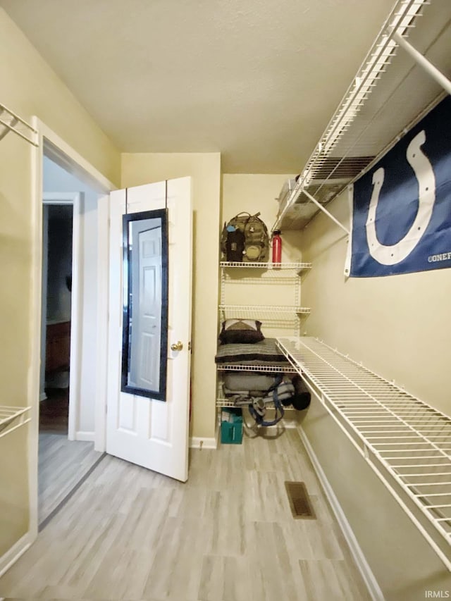 spacious closet featuring hardwood / wood-style floors