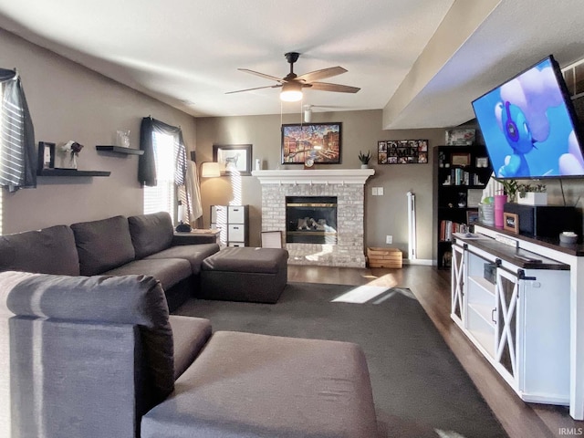 living room featuring ceiling fan, a brick fireplace, and dark hardwood / wood-style flooring