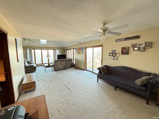 carpeted living room with a textured ceiling and ceiling fan