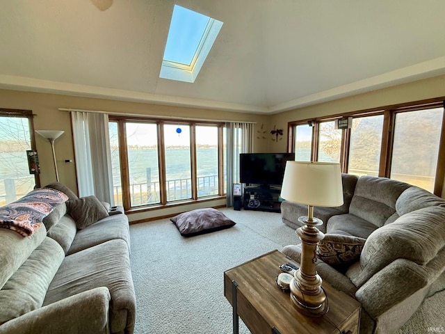 carpeted living room with vaulted ceiling with skylight