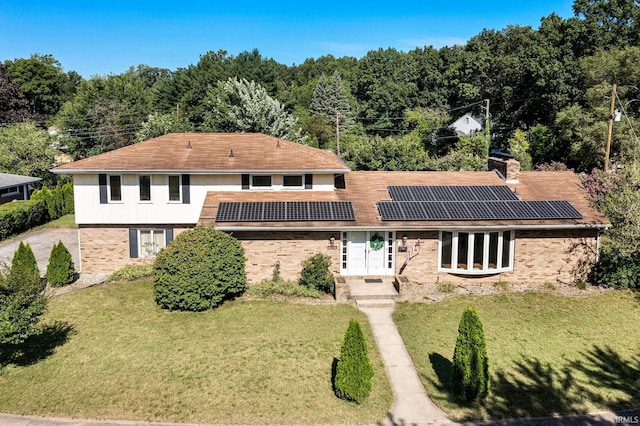 view of front of home featuring a front lawn and solar panels