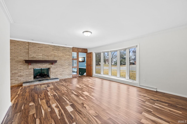 unfurnished living room with a brick fireplace, wood-type flooring, and ornamental molding