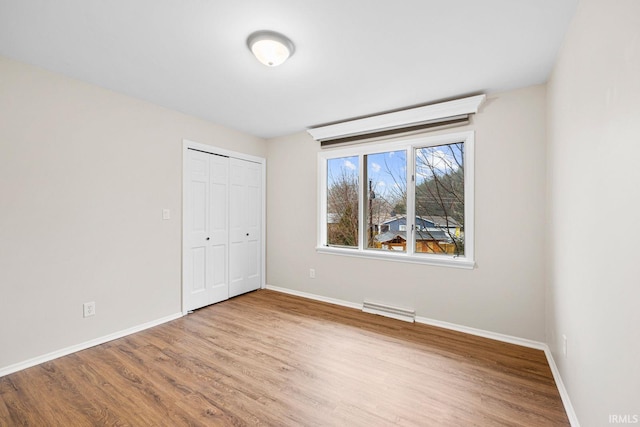 unfurnished bedroom with wood-type flooring and a closet