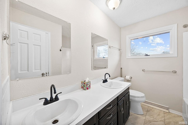 bathroom featuring vanity, a textured ceiling, and toilet