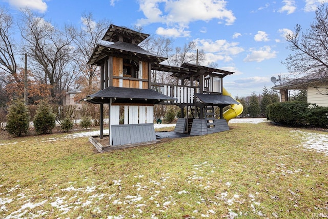 back of property featuring a lawn and a playground