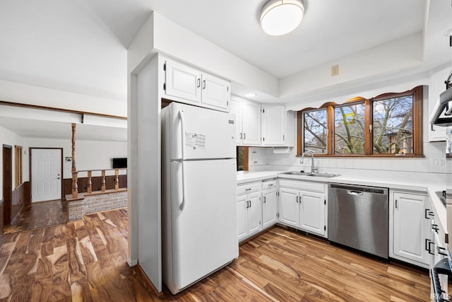 kitchen with white cabinetry, dishwasher, sink, white fridge, and light hardwood / wood-style floors