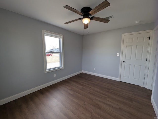 empty room with dark hardwood / wood-style floors and ceiling fan