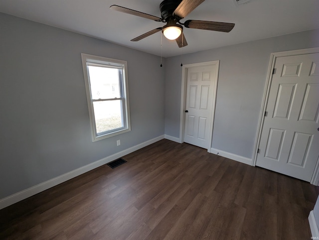 unfurnished bedroom featuring ceiling fan, dark hardwood / wood-style flooring, and a closet