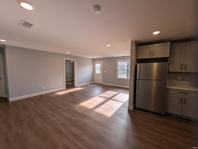 kitchen with gray cabinets, dark wood-type flooring, and stainless steel refrigerator