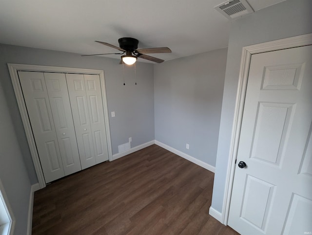 unfurnished bedroom with ceiling fan, dark hardwood / wood-style floors, and a closet