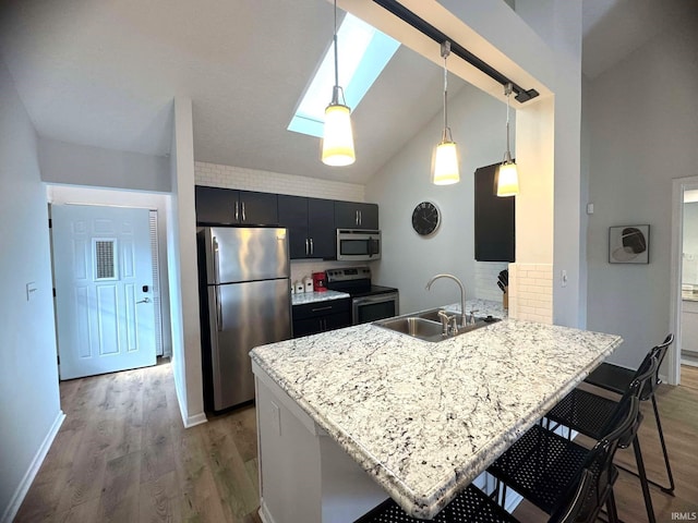 kitchen with sink, decorative light fixtures, a kitchen breakfast bar, kitchen peninsula, and stainless steel appliances