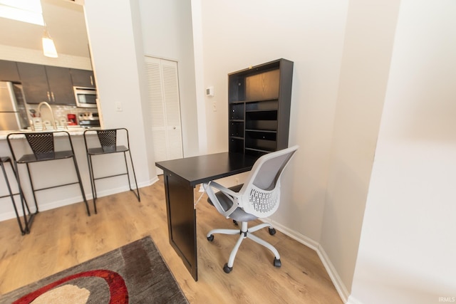 home office with light hardwood / wood-style flooring