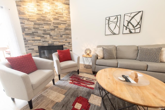 living room with hardwood / wood-style floors and a stone fireplace