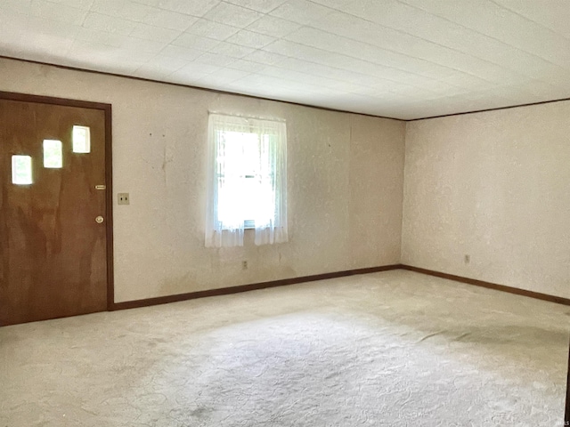 foyer featuring crown molding and carpet