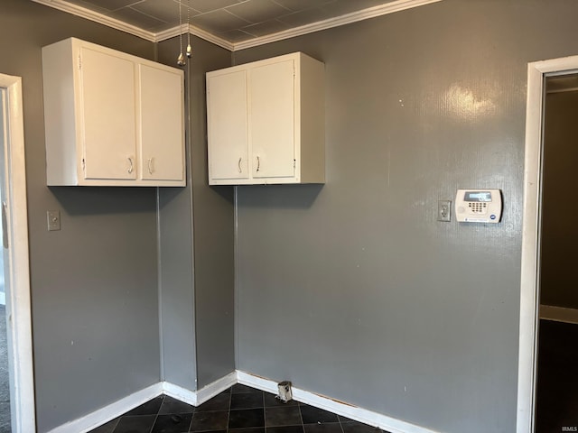 laundry area with ornamental molding and dark tile patterned flooring