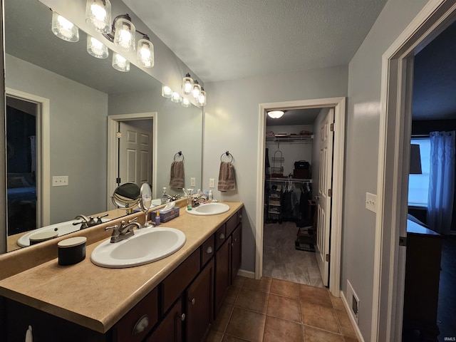 bathroom with vanity, tile patterned floors, and a textured ceiling