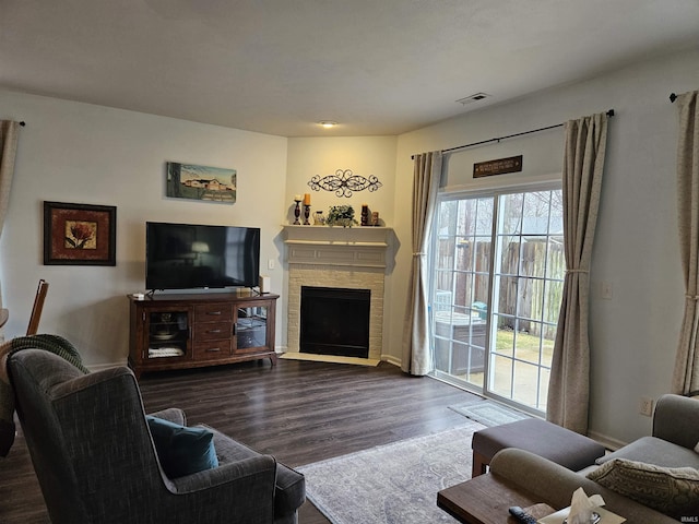 living room featuring dark hardwood / wood-style flooring, a fireplace, and a wealth of natural light