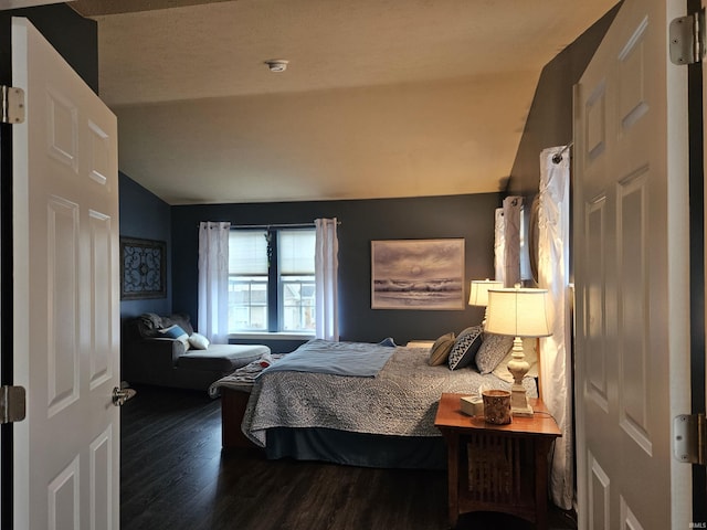 bedroom featuring lofted ceiling and dark hardwood / wood-style floors