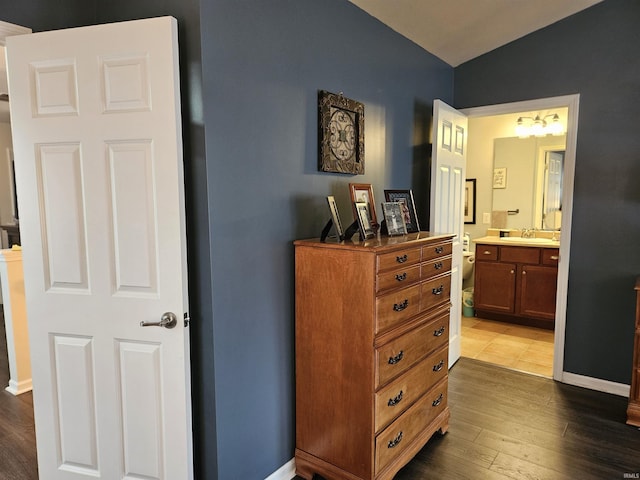 corridor featuring lofted ceiling, sink, and dark hardwood / wood-style flooring