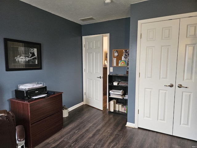 bedroom with a closet, dark hardwood / wood-style flooring, and a textured ceiling