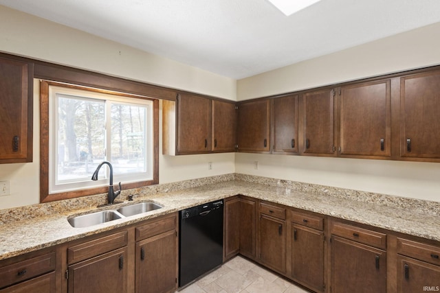 kitchen with dark brown cabinetry, black dishwasher, sink, and light stone countertops