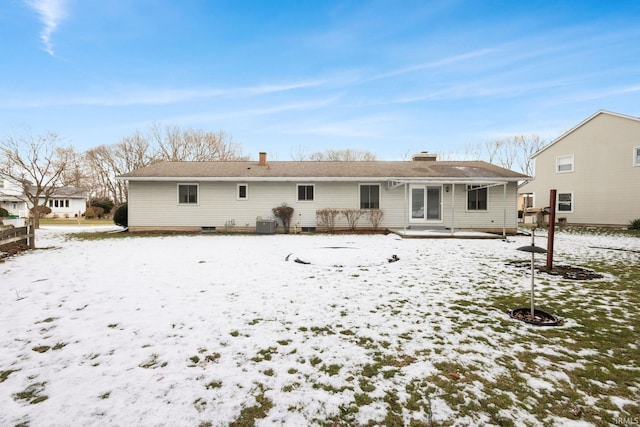 view of snow covered rear of property