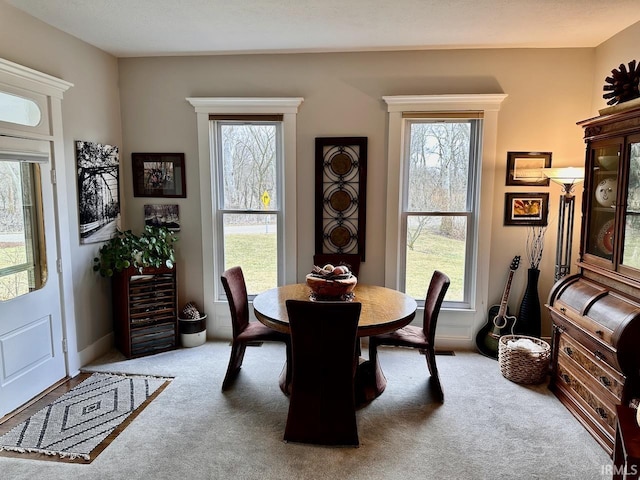 dining space with plenty of natural light and carpet flooring