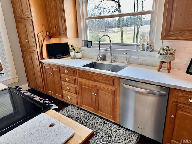 kitchen with tasteful backsplash, dishwasher, and sink