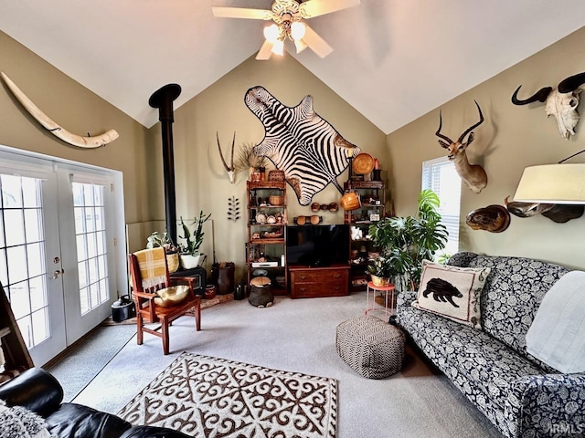 carpeted living room with vaulted ceiling, ceiling fan, and french doors